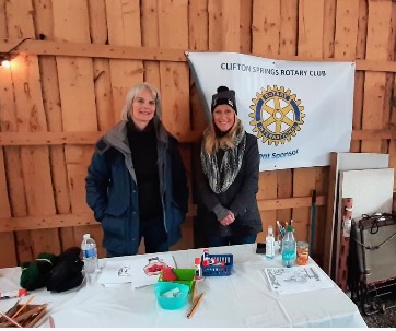 Two club members staffing a booth at a community event