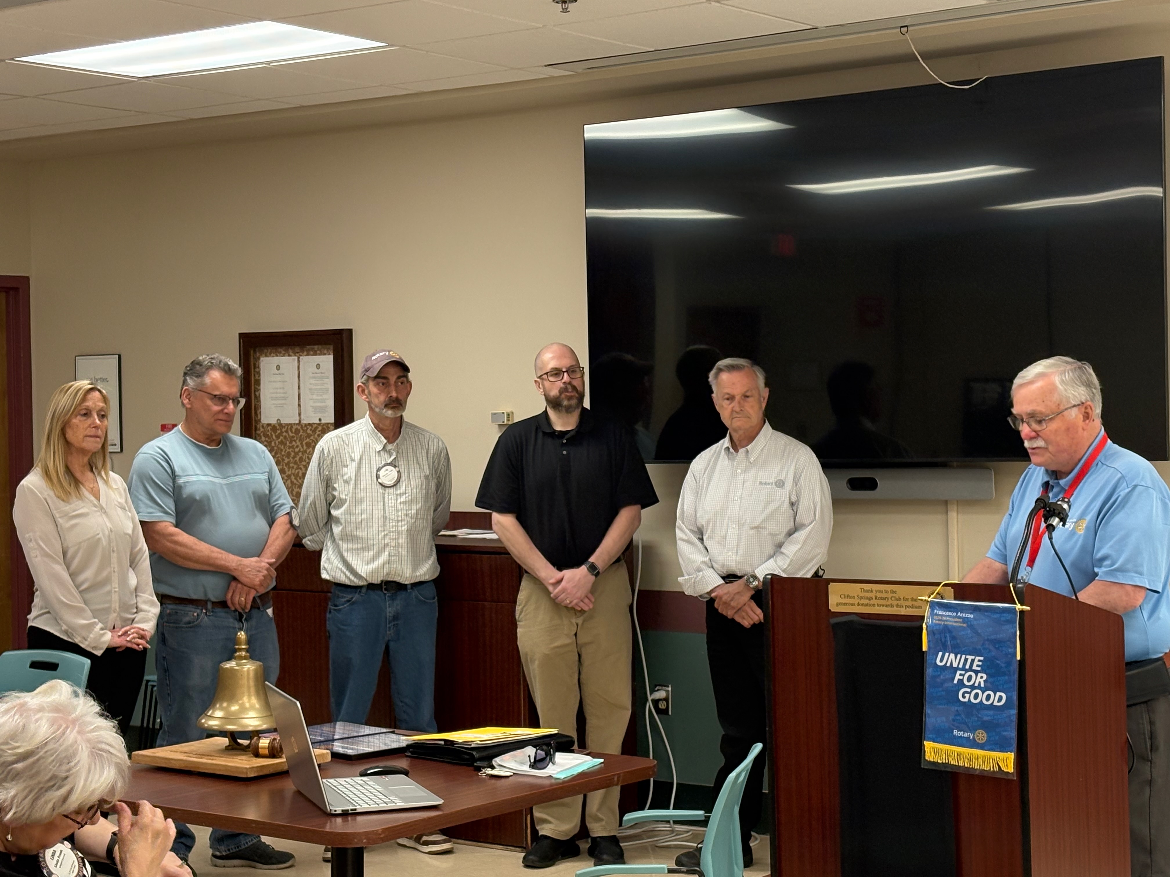 Club members at a meeting with the Rotary International banner displayed